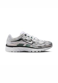 Λευκό και ασημί παπούτσι για τρέξιμο Nike με μαύρο σήμα, πλέγμα στην επιφάνεια, στρώσεις επικαλύψεων και υφασμένο λευκό πέλμα, σε προοπτική από το πλάι.
