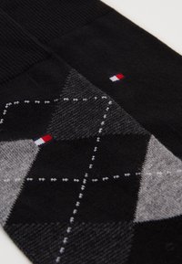 Schwarz- und grau-karierte Socken aus einer Baumwollmischung, mit weißen Nähten und roten, weißen sowie blauen Logoakzenten.