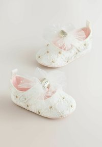 Hvide broderede babysko med lyserød foer, hver sko har en tylsløjfe og små gyldne detaljer. Flade såler og en sikker rem.