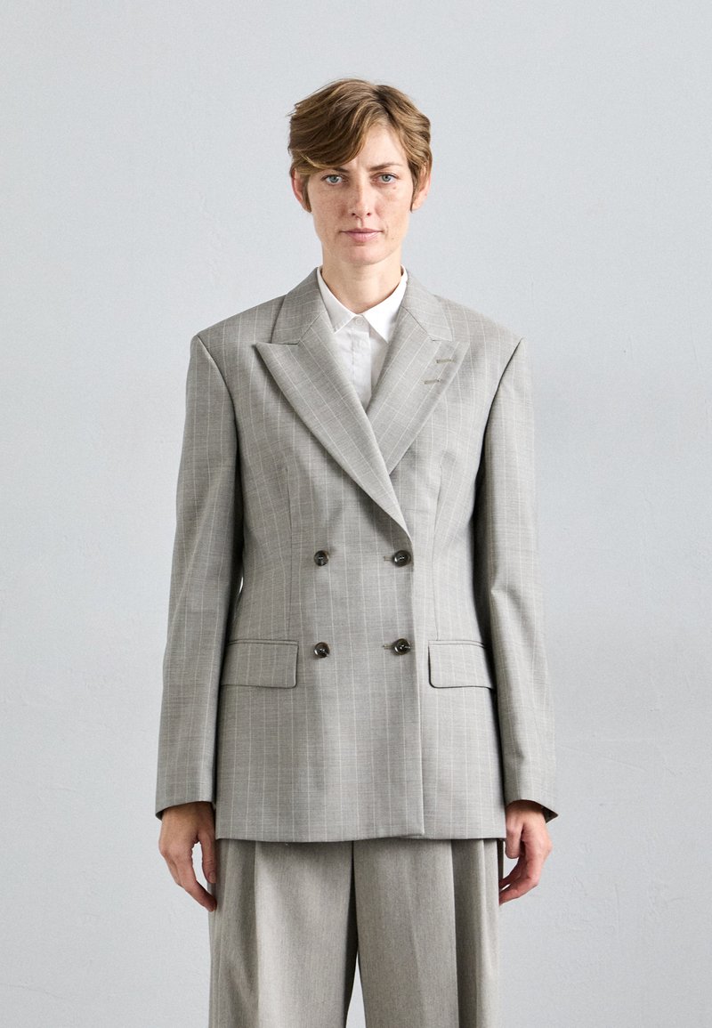 Light gray double-breasted blazer with a pinstripe pattern, notched lapels, and two front pockets. Complemented by a white collared shirt.