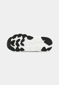 Λευκή και μαύρη λαστιχένια σόλα παπουτσιού τρεξίματος HOKA που δείχνει υφή λαβής με μοτίβα και το λογότυπο της μάρκας στο κέντρο.