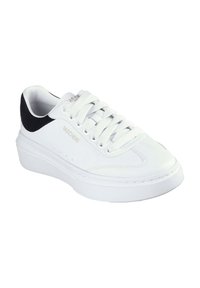 Zapatilla deportiva blanca con una parte superior de cuero liso, acento en el talón de ante negro texturizado, lengüeta acolchada y cordones blancos. Suela de goma ligera.