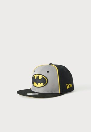 Casquette snapback noire et grise avec bordure jaune et logo Batman à l'avant, présentée sur un fond clair uni.
