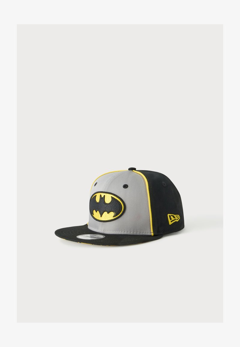 Casquette snapback noire et grise avec bordure jaune et logo Batman à l'avant, présentée sur un fond clair uni.