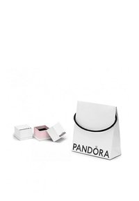 Biela darčeková taška s čiernou rúčkou a logom "PANDORA". Obsahuje dve malé krabičky: jednu bielu a jednu ružovú, obe s čiernym interiérom.