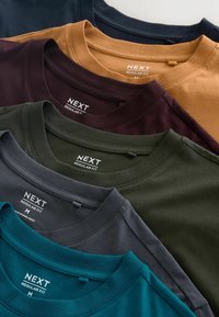 Pieci T-krekli izkārtojumā ar pakāpenisku izvietojumu. Krāsas ietver tumši zilu, sinepju, bordo, tumši zaļu un teļu. Visas ir kokvilnas ar apļveida kakla izgriezumu.