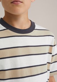 Lagani kratki rukav T-shirt s horizontalnim prugama u bijeloj, bež i tamnoplavoj boji, s rebrastim tamnoplavim ovratnikom i mekanom teksturom.