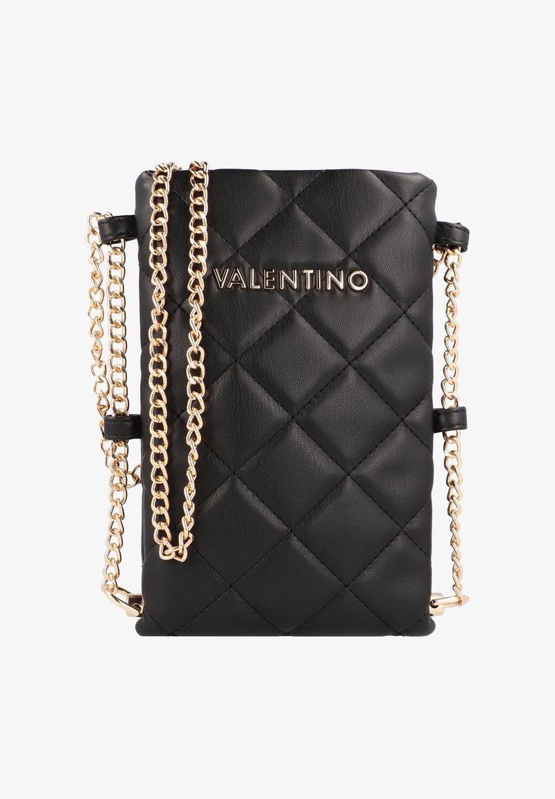 Juodas kvadratinis odinis krepšys per petį su aukso spalvos grandinėmis. Yra aukso spalvos logotipas priekyje ir stačiakampė forma.