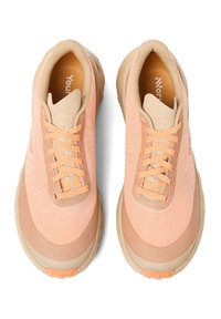 Lichtpeachkleurige sportchoenen met een textiel bovenkant, crèmekleurige accenten, zes oogjes en een gevoerde zool. Lichte veters en logo zichtbaar.