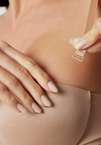 Nude strapless bh met een gladde, strakke textuur. Verstelbare band tussen de vingers, met een kleine plastic sluiting op de voorgrond.