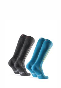 Tres pares de calcetines hasta la rodilla: dos en gris con un acabado texturizado y uno en azul, con acentos amarillos y logotipos en las suelas.