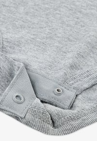 Γκρι βαμβακερό ύφασμα με υφή, διαθέτοντας γιακά με λεπτομέρειες με κουμπιά τύπου σναπ για ασφαλές κλείσιμο.