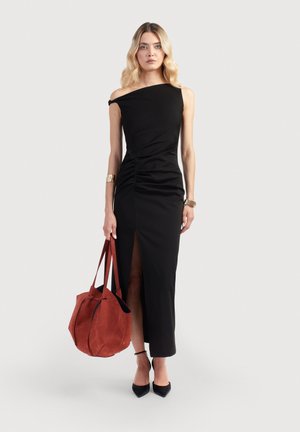 Juodas off-shoulder suknelė su prigludusia liemene, raukiniais ir šonine plyšiu. Pridėta didelė raudona zomšos rankinė ir juodi smailiakulniai bateliai.