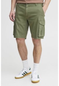 Cargo shorts i olivengrønt bomuldsstof, med sidelommer, lige snit og en lynlås med knaplukning. Hvide sneakers fuldender looket.