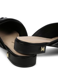 Svarta slid sandals med en slät läderfinish, bred rem och en lätt plattform. Gyllene "M"-detaljering på sidan.