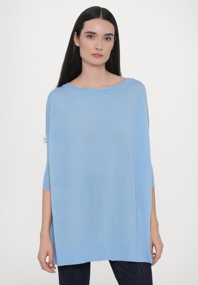 Pulover oversized de culoare bleu deschis, cu mâneci scurte, realizat dintr-un material tricotat moale. Dispune de manșete ribbed și o croială lejeră, relaxată.