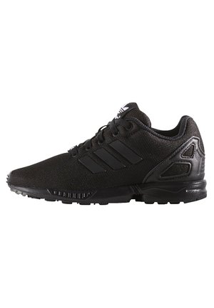 Chaussure de sport Adidas noire avec tige en mesh, trois bandes sur le côté, lacets et semelle texturée, vue de côté extérieur.