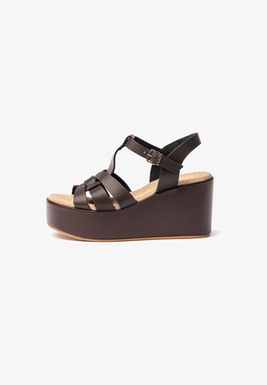 Braune Leder-Wedgesandalen mit einer Plateausohle, ausgestattet mit überkreuzten Riemen und einer verstellbaren Schnalle für einen sicheren Sitz.