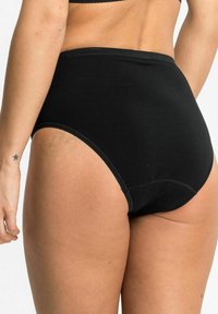 Hoch geschnittene schwarze Baumwollslips mit glatter Textur und subtilen Nähdetails. Das Design ist klassisch und bietet vollständige Abdeckung.