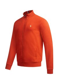 Orange Zip-Jacke mit hohem Kragen, gerippten Bündchen und einem Logo auf der linken Brust. Hergestellt aus einem weichen, strukturierten Stoff mit Seitentaschen.