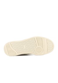 Semelle de chaussure en caoutchouc beige avec des motifs texturés incluant des formes de diamant, des zigzags et des rainures circulaires pour une bonne prise et traction.