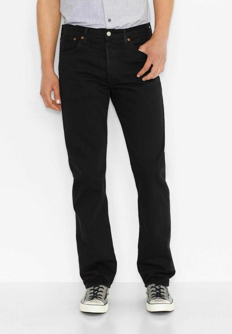 Zwarte rechte jeans met vijf zakken, zichtbare stiksels en een knoopsluiting. Draag ze met grijze sneakers en een lichtblauw shirt.