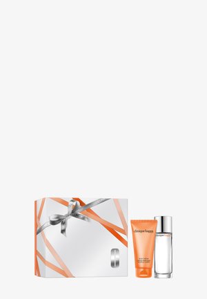 Set de regalo con crema corporal Clinique Happy en un tubo naranja y fragancia a juego en un frasco transparente con tapa plateada, junto a una caja blanca con rayas naranjas y un lazo plateado.