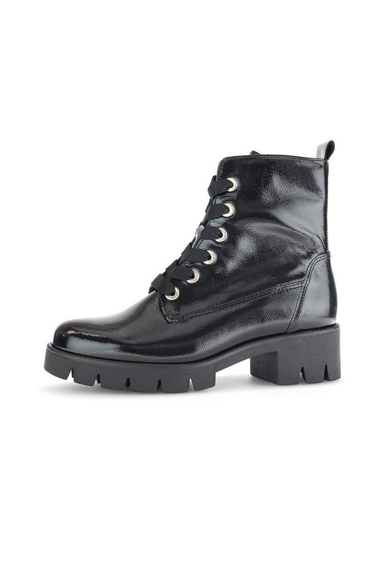 Bottines en cuir verni noir avec une semelle épaisse, bout rond et œillets en métal. Fermeture à lacets et languette à l'arrière.