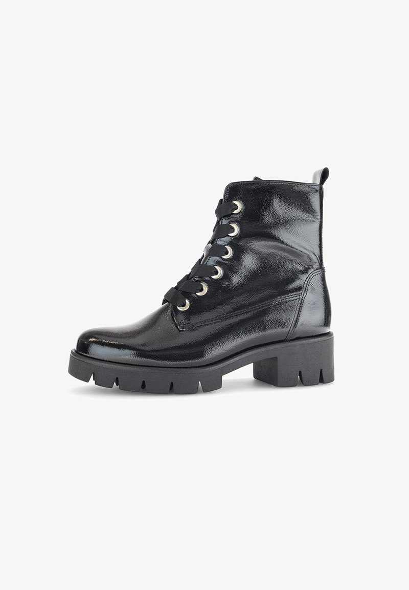 Černé lakované kožené kotníkové boty s robustní podrážkou, kulatou špičkou a kovovými očky. Šněrování a poutko na zadní straně.
