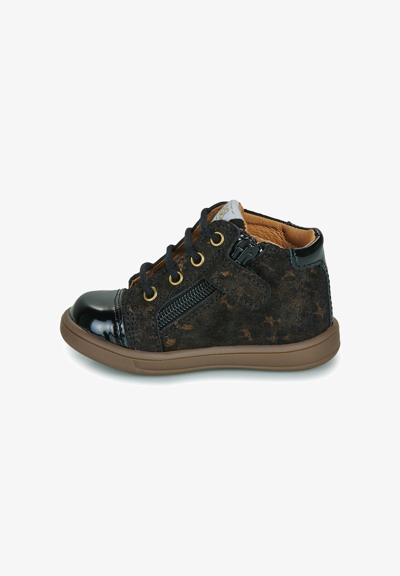 Chaussure noire pour tout-petit en daim et cuir verni, semelle marron, lacets à l'avant, fermeture éclair latérale et intérieur rembourré couleur fauve.