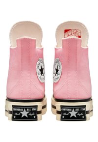 Růžové plátěné sneakers s vysokým střihem, které mají gumovou podešev, logovou nášivku a zaoblenou špičku. Design obsahuje kontrastní černé akcenty na podešvi.
