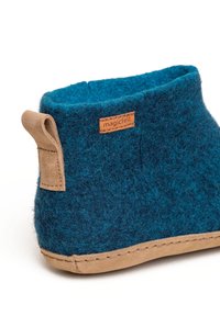 Filzpantoffel in Türkis mit braunem Wildlederboden. Verfügt über eine genähte Kante und ein kleines Lederschild an der Seite zur Markenkennzeichnung.