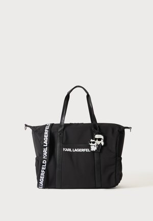 Sac cabas noir Karl Lagerfeld avec longues anses, texte blanc marqué et porte-clés personnage de dessin animé attaché à l'avant.