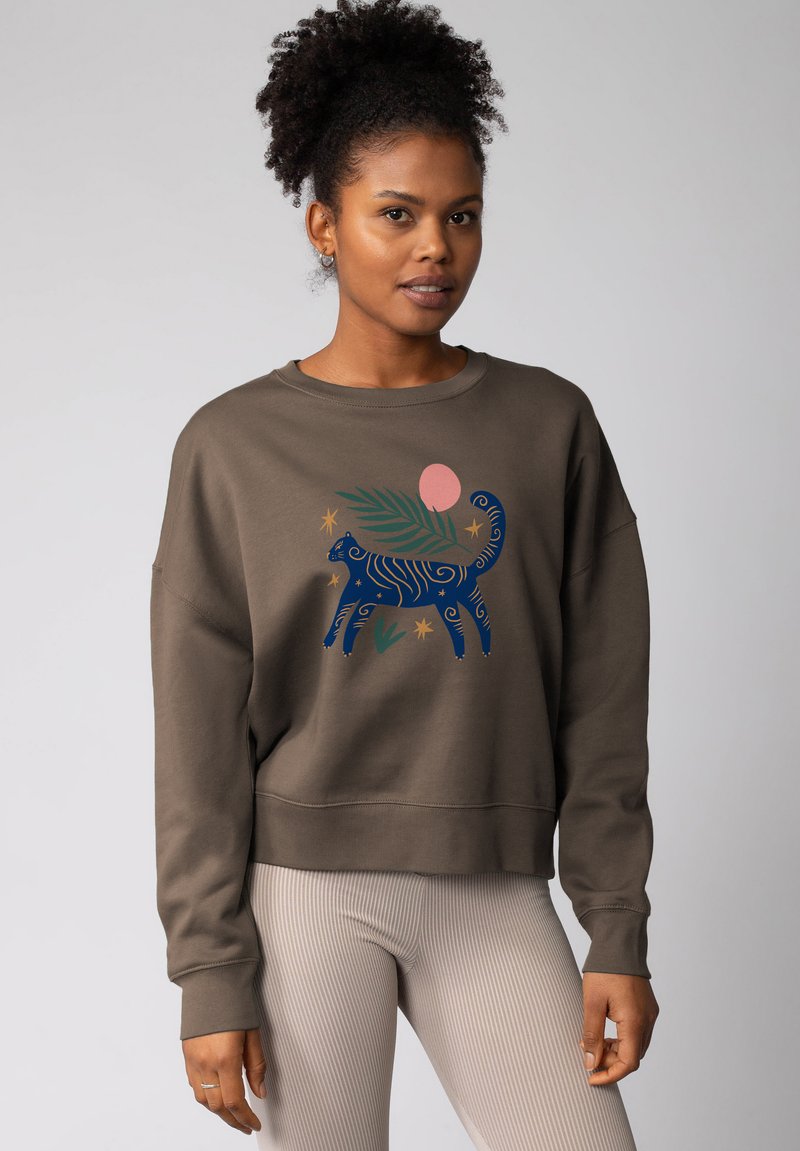 Bruine sweatshirt met een grote blauwe en roze graphic van een gestileerd dier en loofdesign; zachte textuur, relaxte pasvorm en geribde manchetten.