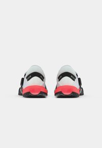 Sport shoes with a breathable mesh upper in grey, black accents, and a red sole. Features adjustable straps and a textured outsole.
