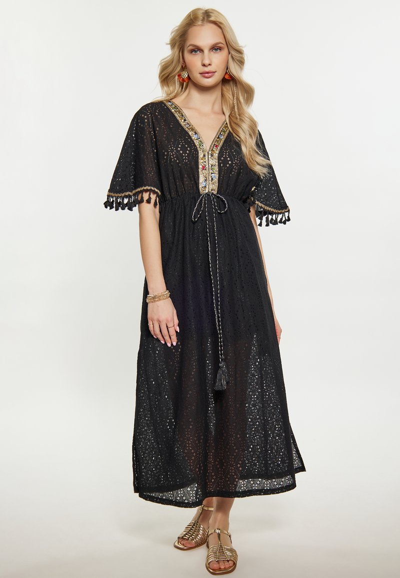 Rochie maxi din dantela neagra, cu maneci scurte, decolteu in V, decorata cu detalii colorate din mărgele si ciucuri. Are o talie ajustabila cu snur.