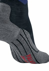Calcetín gris y azul marino con una plantilla texturizada, talón reforzado y logo rojo. Presenta un acolchado contorneado y un diseño a rayas a lo largo de los lados.