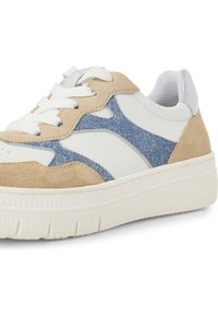 Sneaker beige e bianche con un accento denim blu, texture scamosciata, lacci bianchi e suola in gomma spessa con linee verticali.