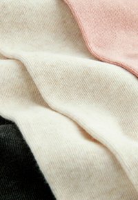 Baumwollmischgewebe mit Abschnitten in Rosa, Creme und Schwarz. Weiche Textur mit feinem Rippenstrickmuster und glatten Kanten.