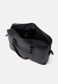 Melna ādas portatīvā datora soma ar rāvējslēdzēja aizdari, divām rokturiem un iekšējām nodalījumiem organizācijai; gluda tekstūra un minimālistisks dizains.