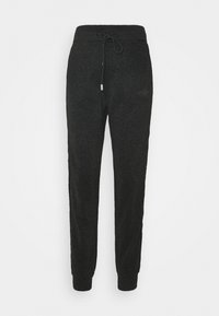Schwarze Jogginghosen aus strukturiertem Material, mit einem Kordelzugbund, gerippten Bündchen und einem kleinen Logodetail an der Seite.