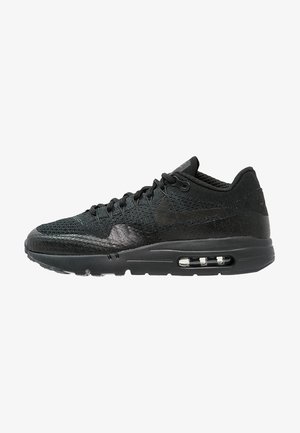 Sort Nike Air Max sneaker med mesh-overdel, synlig luftpolstring i sålen og snøredesign, vist i profil.