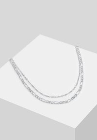 Hõbedast kihiline kettnäär, millel on erinevad lingikujundid, sile tekstuur ja poleeritud viimistlus, esitatud heledal taustal.