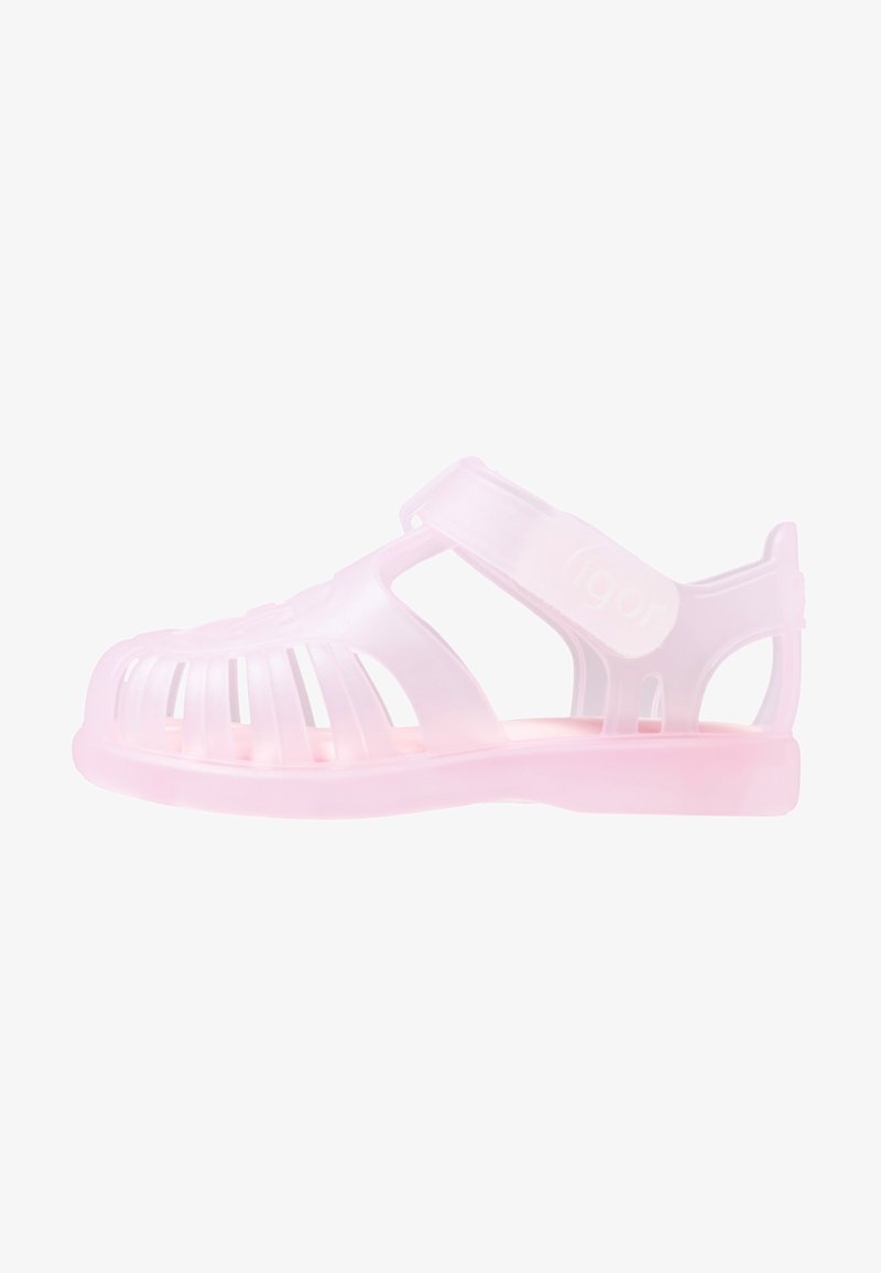 Translucent pink plastic sandal with open design, adjustable strap, and slotted upper for ventilation; flat sole, lightweight construction.
