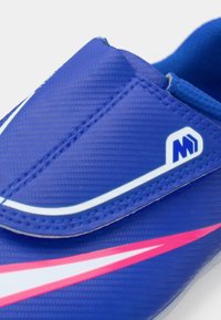 Nærbillede af blå sportsko med hvid og pink swoosh-design og et lille hvidt og blåt logo på den øverste del.