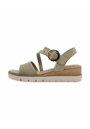 Green wedge sandals with mesh detailing, ankle strap, circular buckle, and a light sole. Textured material with a wooden accent on the heel.