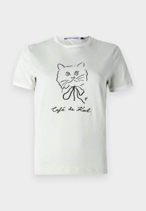 Camiseta de algodón verde claro con mangas cortas, cuello de canalé y un diseño gráfico de un gato negro con el texto "Café de Karl" impreso debajo.