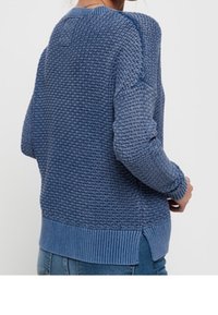 Knitted sweater in varying shades of blue, featuring a textured pattern, ribbed cuffs, and side slits at the hem.