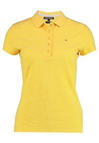 Polo shirt jaune en coton texturé. Équipé d'un col, d'une patte de boutonnage à cinq boutons et d'un petit logo sur la poitrine gauche. Manches courtes.