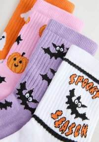 Colorful socks: orange with ghosts, pink with pumpkins, purple with bats, and white with "Spooky Season" text, ribbed texture throughout.